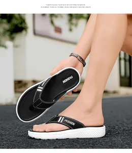 Détail de tongs pour hommes à semelle épaisse montrant le logo FASHION et la texture