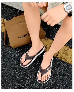 Gros plan de tongs marron pour hommes avec semelles blanches et lanières en tissu