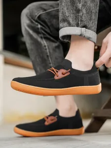 Detail of black knit mesh upper and brown rubber sole on breathable men's loafers