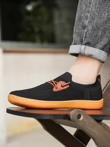 Detail view of breathable black knit barefoot sneaker with durable orange rubber sole