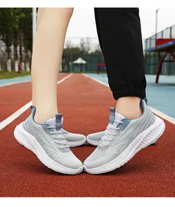 Close-up of lightweight grey breathable mesh running shoes on a red athletic track