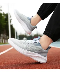 Detail of breathable mesh upper and thick cushioned sole on running shoes on a red track