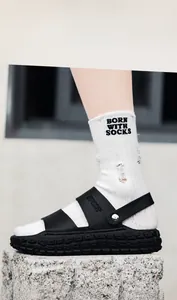 Gros plan de sandales de sport noires avec semelles épaisses et texture de cuir litchi