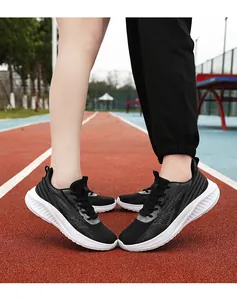 Detail shot of breathable black mesh running shoes with thick cushioned white soles on track