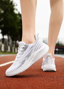 Detail of white mesh running shoes on a red track featuring breathable lightweight fabric