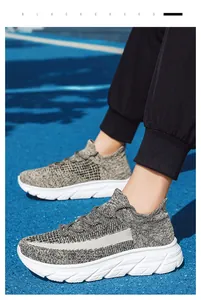Vue portée de chaussures de marche en maille grise légère sur une piste d'athlétisme