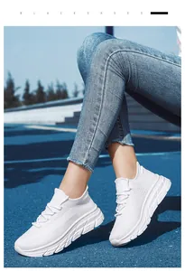 Vue portée de baskets blanches en mesh respirant sur une piste d'athlétisme bleue