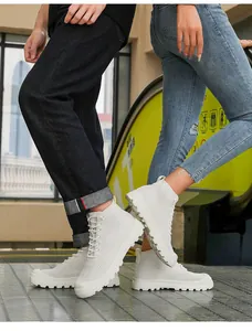 Street style low-angle shot of white high-top knit sneakers with thick non-slip soles