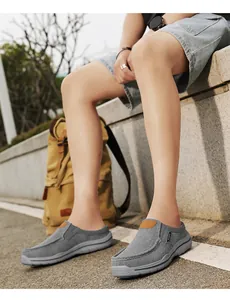 Outdoor lifestyle shot of grey canvas loafers with brown leather patch and rubber sole