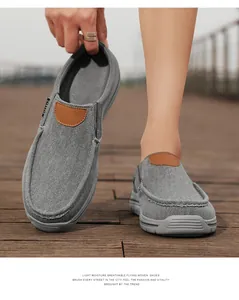 Detail of grey slip-on canvas shoes with breathable woven fabric and brown leather accent