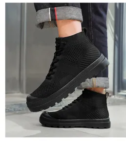 Detail of black breathable knitted mid-top sneaker with thick anti-slip rubber sole