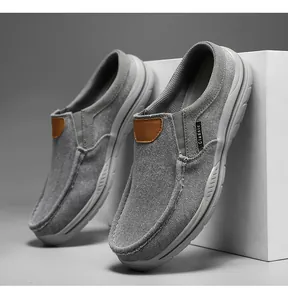 Detailed close-up of grey canvas loafer mule featuring classic leather patch and thick sole