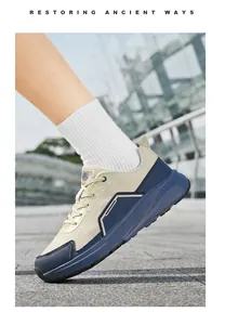 Close-up of beige mesh and navy blue leather wide-fit walking sneakers on white socks