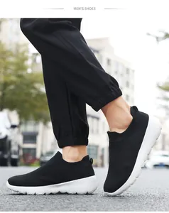 Dynamic low-angle shot of men's black breathable mesh slip-on shoes with white sole