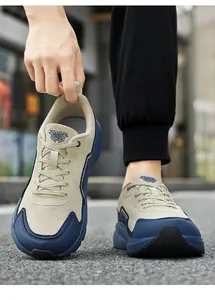 Macro detail of breathable beige mesh and navy synthetic overlays on wide-toe sneakers
