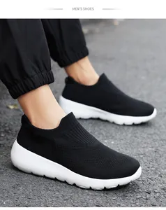 On-foot side view of men's black breathable mesh slip-on shoes with white soles