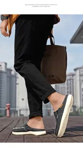 Men's grey canvas slip-on mule featuring a white rubber sole and classic casual design