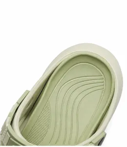 Detail view of wavy non-slip footbed and thick EVA sole on green beach sandals