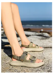 Macro detail of army green outdoor sandals with thick EVA soft sole on a beach