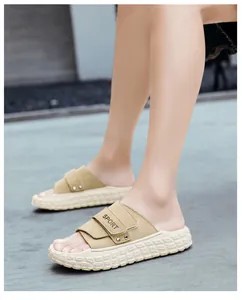 Close-up of beige thick-sole sport slides with adjustable velcro straps and non-slip texture
