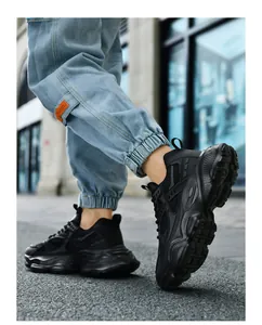Detail of black chunky sneakers featuring breathable mesh and wave-shaped platform sole