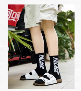 Close-up van witte kurken sandalen met dubbele bandjes en gespen in streetwear-stijl