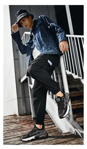 Street style detail of men's navy denim jacket with black cargo pants and dad sneakers
