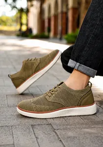 Outdoor-Aufnahme der atmungsaktiven, olivgrünen Strick-Sneaker für Herren mit dicker weißer Sohle
