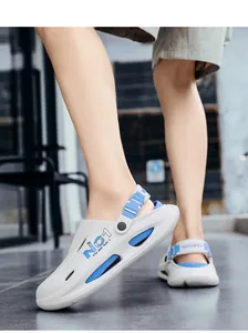 Detalle de zuecos blancos transpirables con correas azules ajustables y texto deportivo