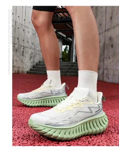 Detail van trendy hardloopschoenen met dikke lichtgroene vinzool en leer-mesh bovenwerk