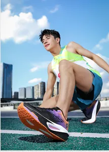 Paarse gradiƫnt hardloopschoenen met gedempte zolen gefotografeerd op een atletiekbaan