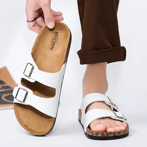 Detail van witte sandalen met dubbele gesp met kurkzool textuur en verstelbare bandjes