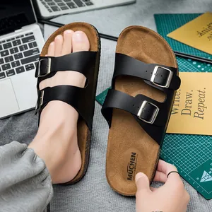 Detail van kurken sandalen met zwarte dubbele bandjes en zilverkleurige gespen