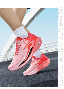 Scatto dinamico di scarpe da corsa rosa sfumate con mesh traspirante e suola spessa