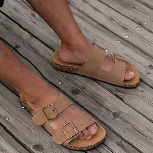 Klassieke bruine suède kurken sandalen met verstelbare metalen gespen op houten vloer