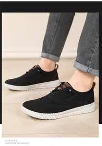Nahaufnahme der schwarzen Mesh-Sneaker mit weißer Noppensohle und brauner Fersenschlaufe