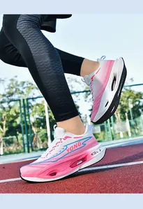 Close-up of pink and white gradient carbon plate running shoes on a red athletic track