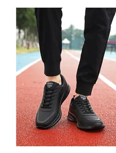 Detailopname van zwarte waterdichte sneakers met veters op een atletiekbaan