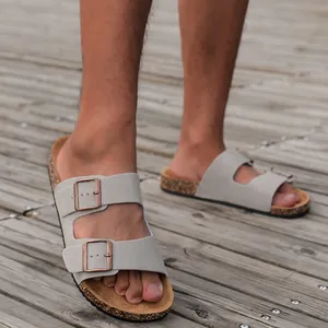 Detailopname van grijze suède bandjes met verstelbare gespen op kurken sandalen
