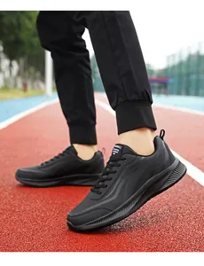 Detail van waterdichte zwarte herensneakers met dynamische golfpatronen op een rode baan