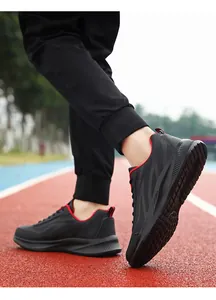 Detail van zwarte waterdichte hardloopschoenen voor heren met rode accenten op de sportbaan