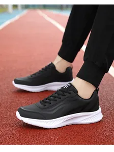 Detail van lichte zwarte waterdichte hardloopschoenen op een rode atletiekbaan