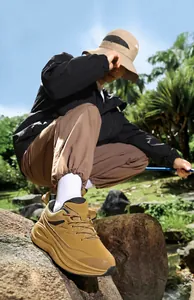 Outdoor camel hiking shoes with cushioned midsole shown in a garden setting