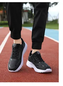 Dettaglio di scarpe da corsa in pelle nera da uomo con suole bianche su pista
