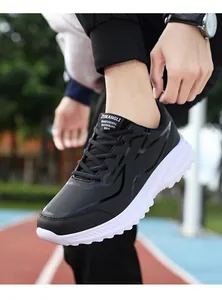 Dettaglio scarpa sportiva impermeabile da uomo con suola antiscivolo bianca e pelle nera di qualità