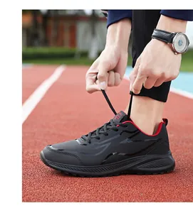 Dettaglio scarpe da corsa in pelle nera con fodera rossa su una pista di atletica