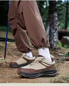 Macro detail of men's hiking shoe showing khaki leather stitching and thick EVA cushioning