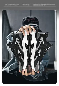 Close-up of trendy chunky sneakers held by hands showcasing leather mesh stitching