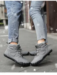 Detail of grey winter snow boots with speed lacing and anti-slip rubber soles in the snow