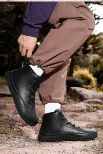 Detalle de botas de senderismo negras en cuero texturizado con suelas de goma antideslizantes
